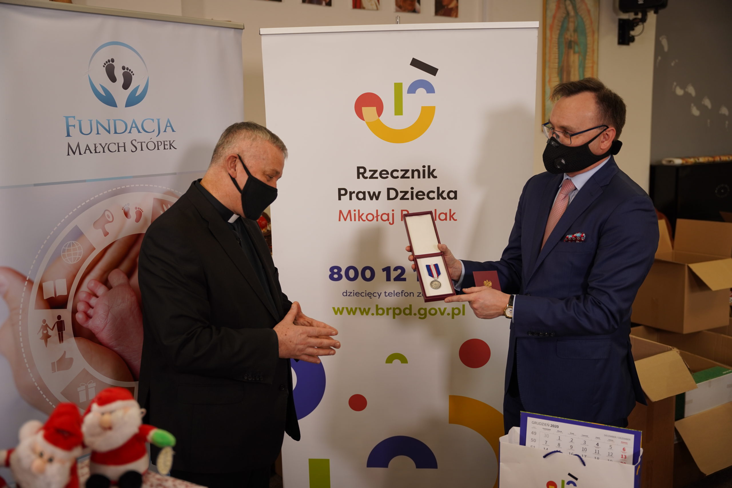 Prezes Fundacji Małych Stópek ks. Tomasz Kancelarczyk odbiera Odznakę Honorową z rąk Rzecznika Mikołaja Pawlaka