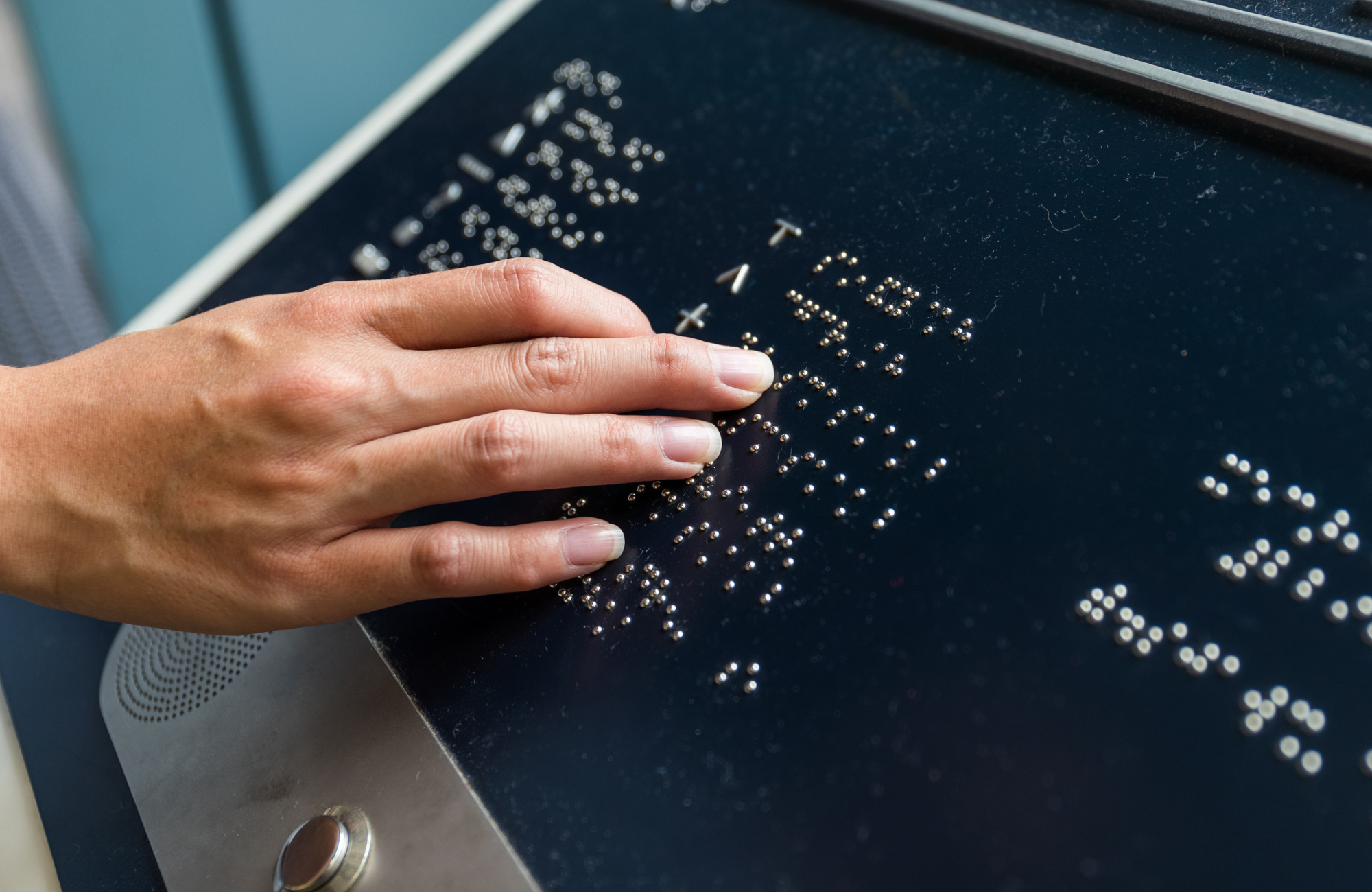 Zdjęcie tablicy braille'a i ręki.
