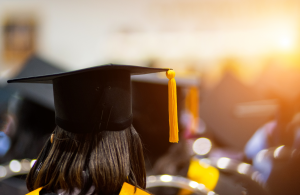 Zdjęcie dziewczyny w czapce absolwenta stojącej tyłem.