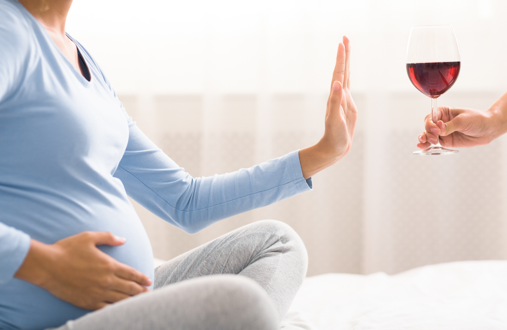 Kobieta w ciąży odmawiająca wypicia kieliszka wina